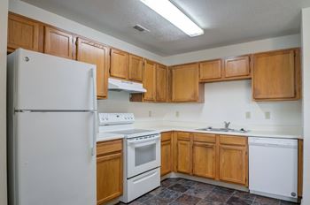 a kitchen with white appliances and wooden cabinets